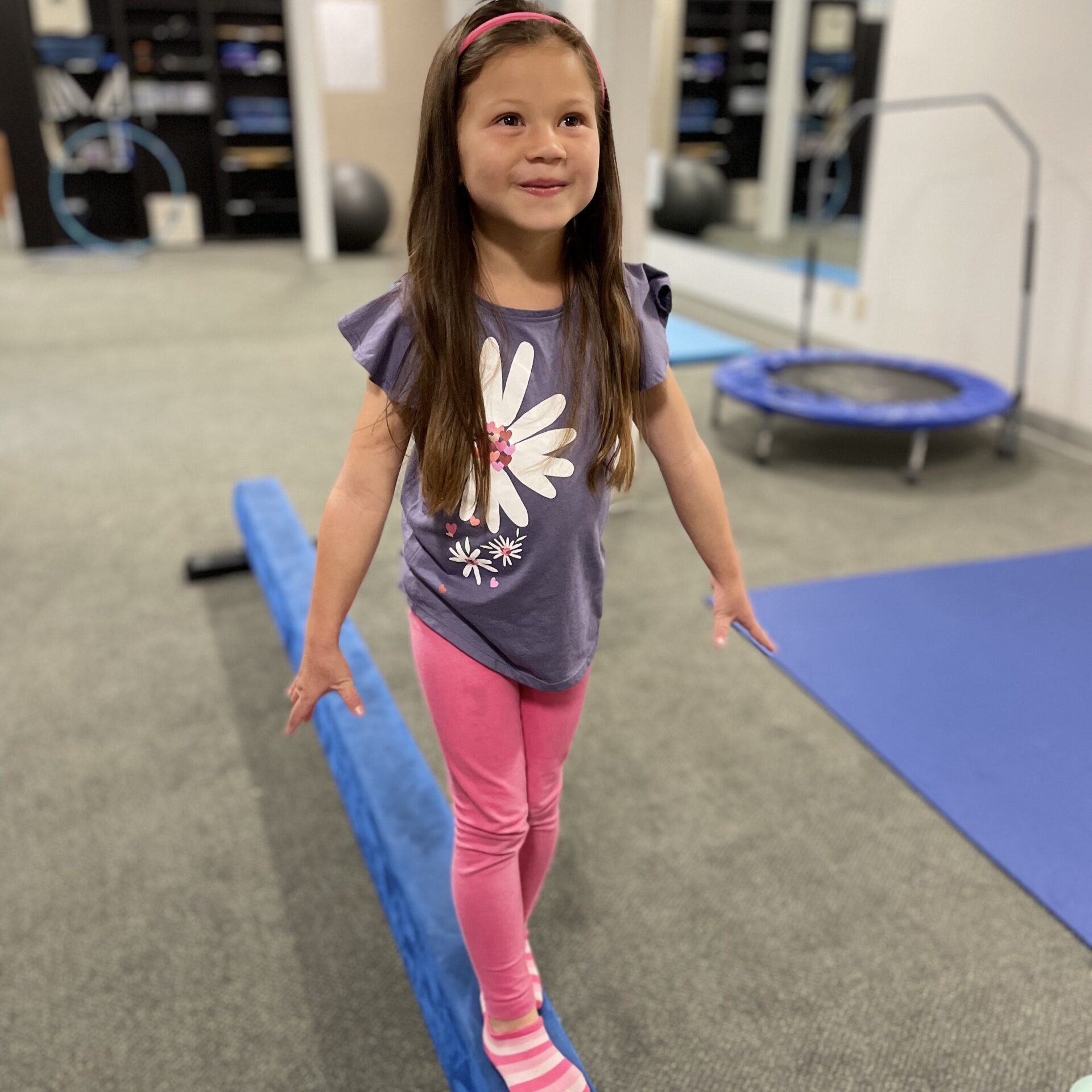 Young girl walking a low balance beam during Core Learning Skills training for retained primitive reflexes at Stowell Learning Center