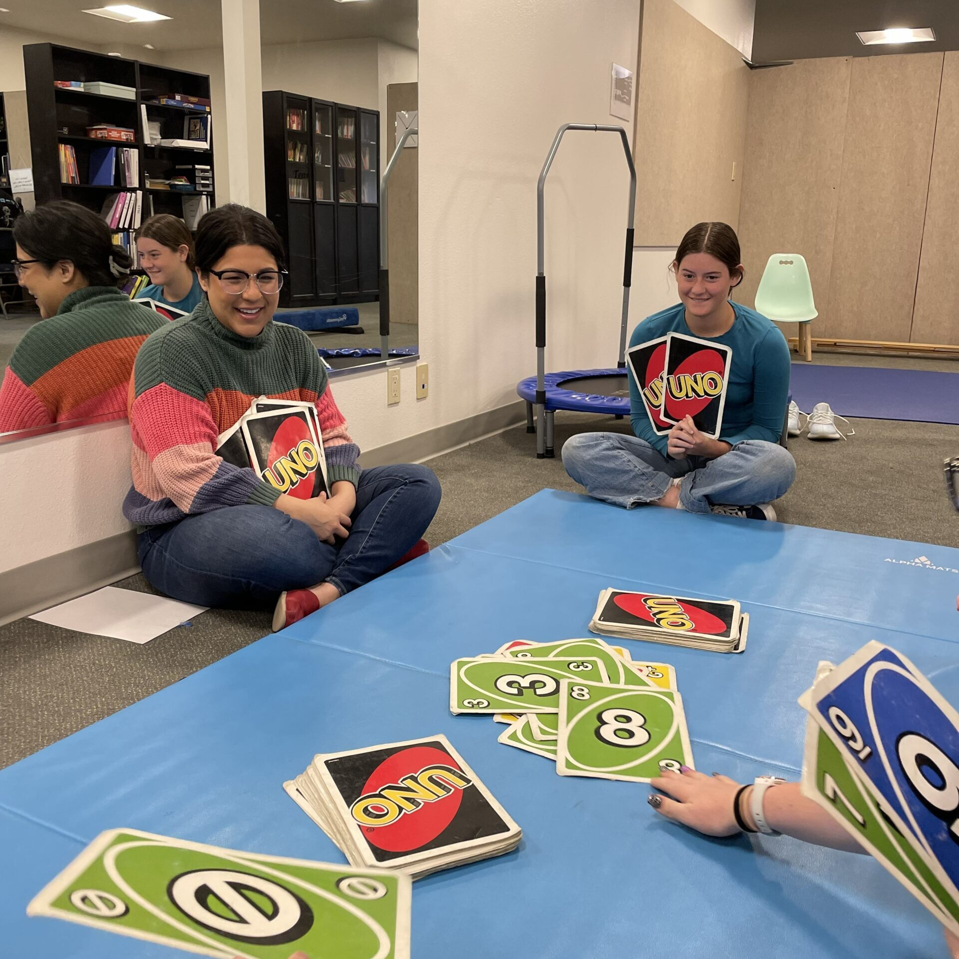 Clinicians and students playing uno card game during summer program