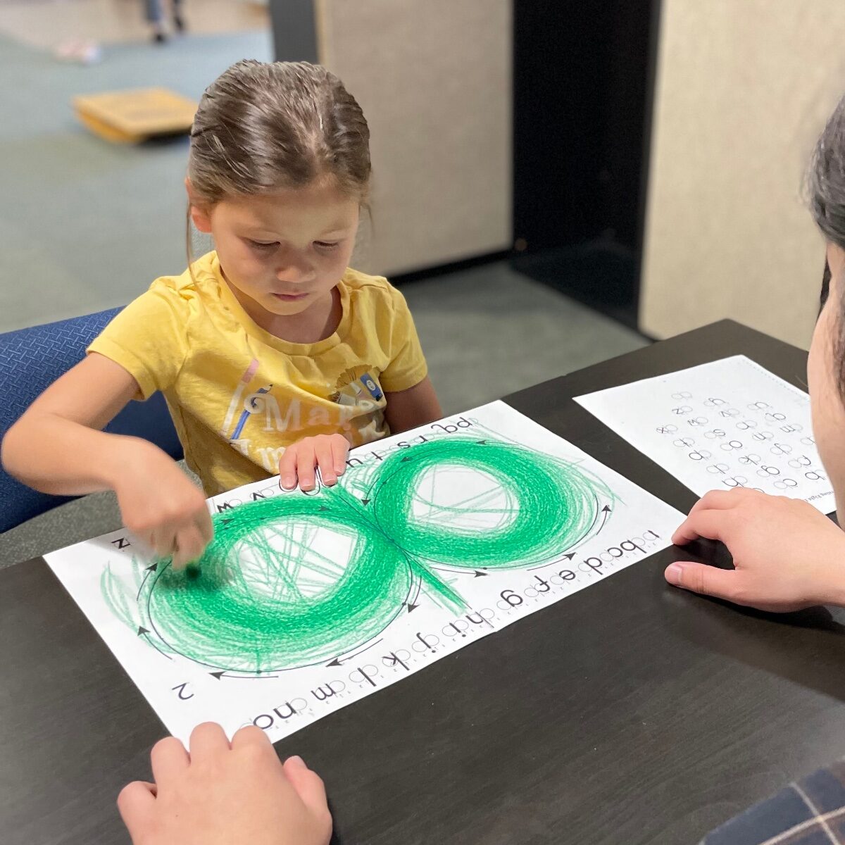 Young student tracing a lazy eight with her clinician during a cognitive learning therapy session for executive function at Stowell Learning Center