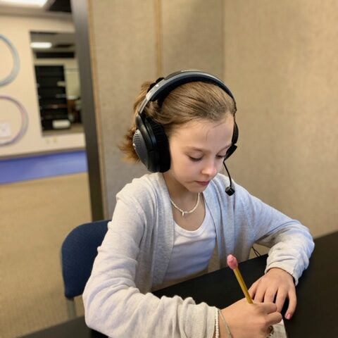 SLC Student wearing headphones for an auditory training session