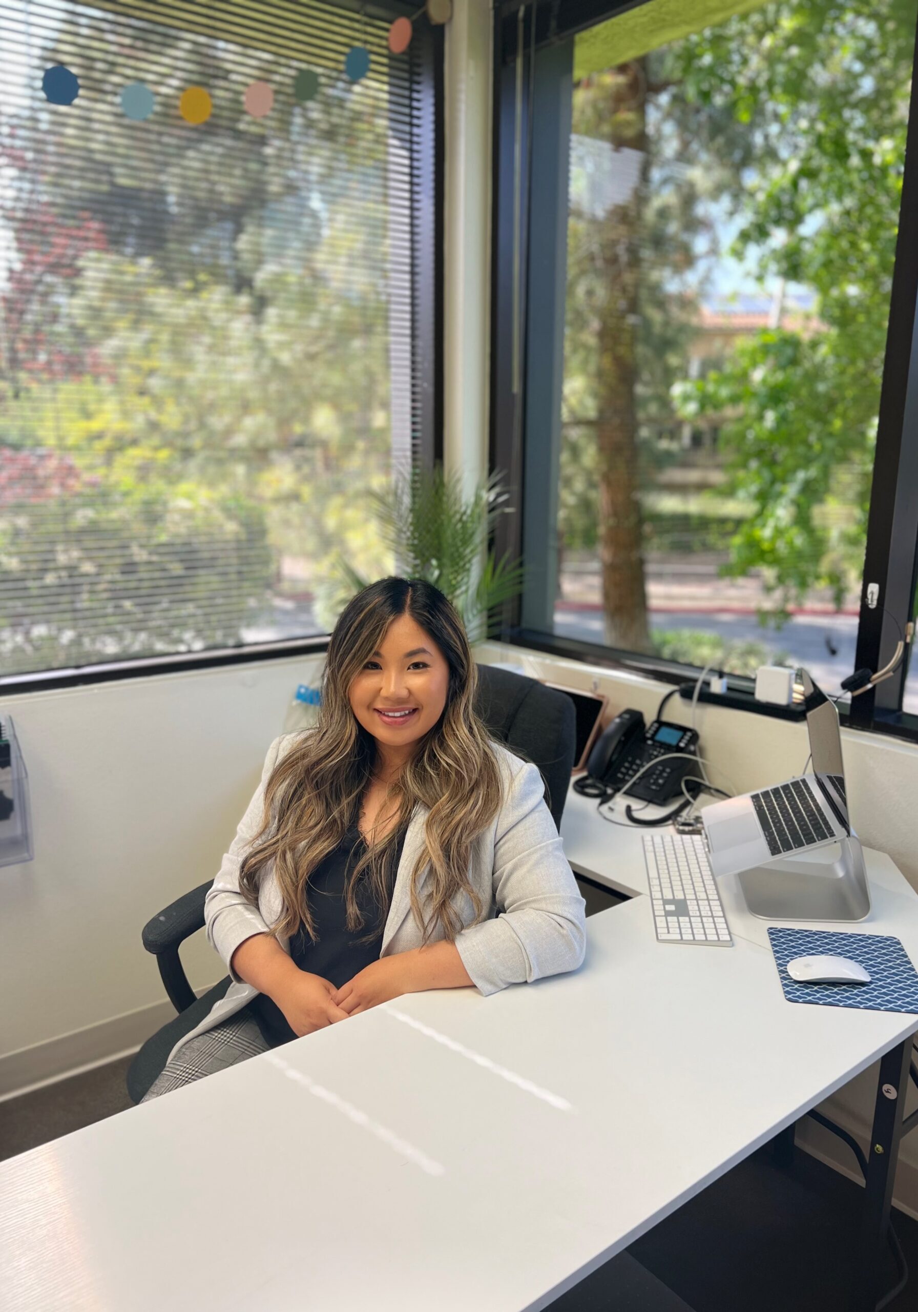 Thousand Oaks Center Director, Sharon Diep, smiling at her desk