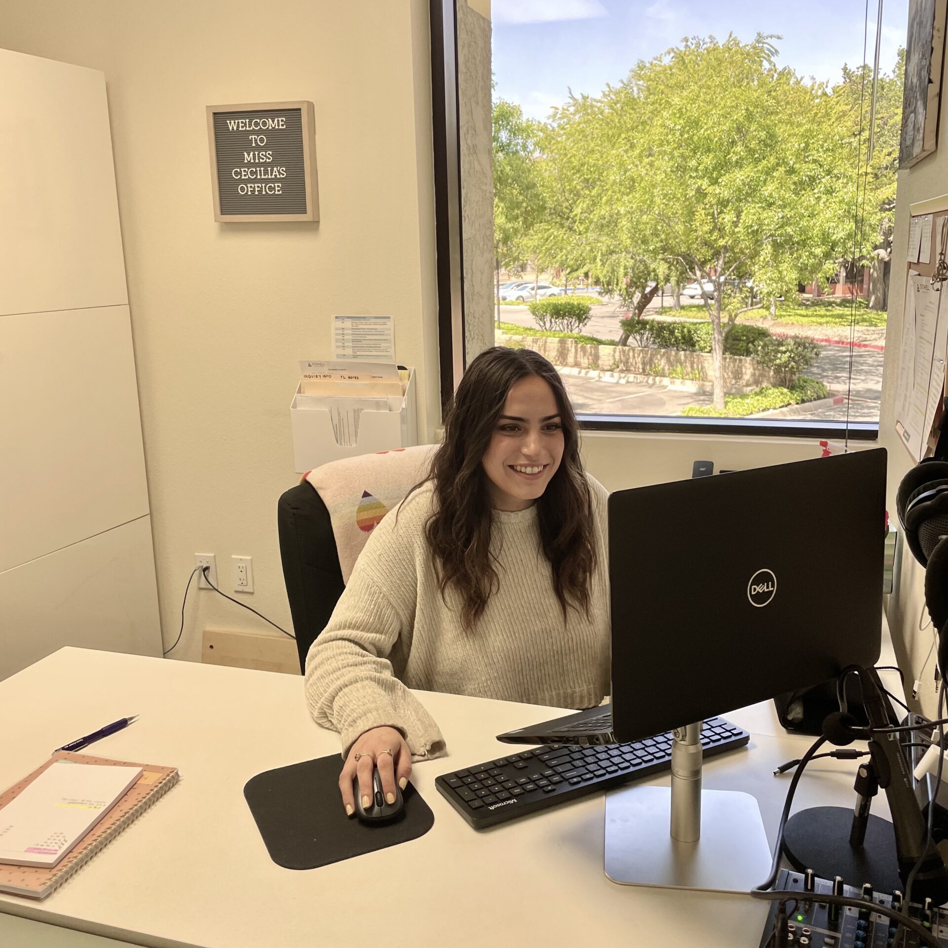 Team Leader smiling seated in front of the computer in Thousand Oaks